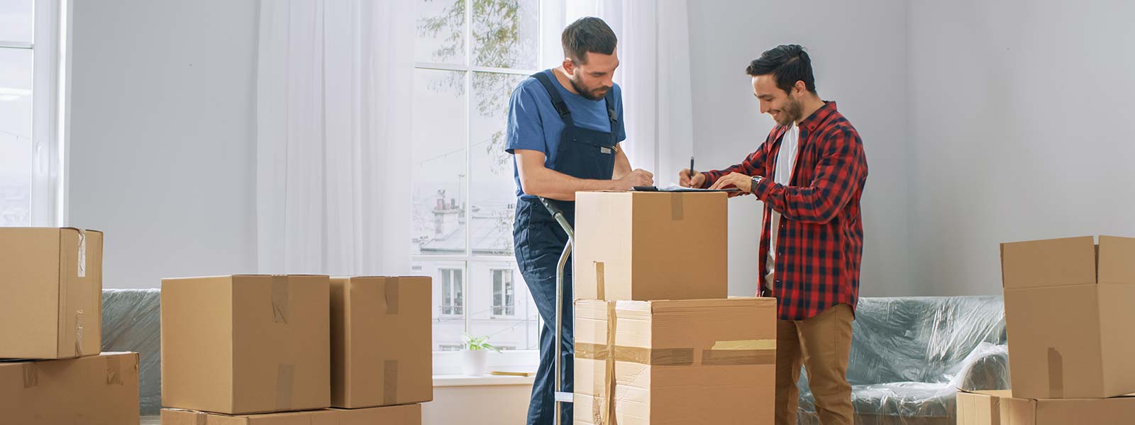 Mover and homeowner sign contract on cardboard boxes